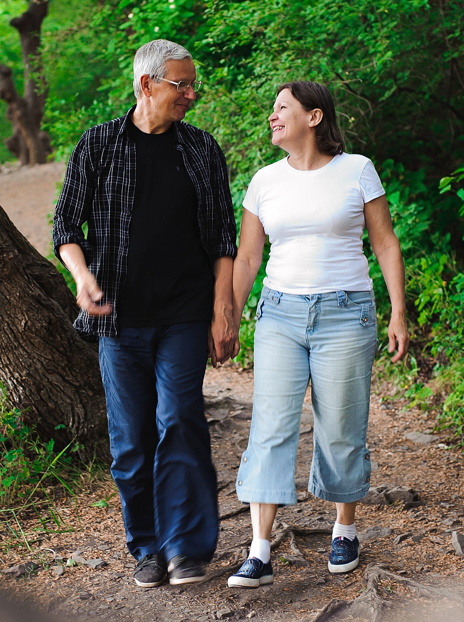 Man and woman walking together on a path in a forest